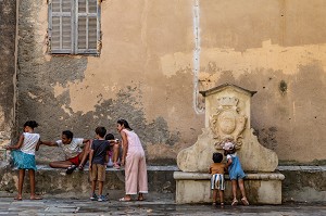 FAMILLE ET ENFANTS PRES D'UNE FONTAINE EN PIERRE SUR LA PLACE GUASCO A BASTIA