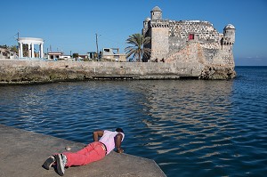 PECHEUR SUR LA DIGUE DEVANT LE FORT DE COJIMAR, PETIT VILLAGE DE PECHEURS A L'EST DE LA HAVANE OU ERNEST HEMINGWAY AIMAIT PARTIR A LA PECHE EN MER, SOURCE D'INSPIRATION DE SON LIVRE 'LE VIEL HOMME ET LA MER', CUBA, CARAIBES 