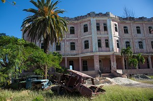 FACADE D'IMMEUBLE ABANDONNE ET CARCASSES DE VOITURES, COJIMAR, PETIT VILLAGE DE PECHEURS A L'EST DE LA HAVANE OU ERNEST HEMINGWAY AIMAIT PARTIR A LA PECHE EN MER, SOURCE D'INSPIRATION DE SON LIVRE 'LE VIEL HOMME ET LA MER', CUBA, CARAIBES 