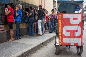 VELO TAXI (BICITAXI) AVEC LE DRAPEAU DU PCF (PARTI COMMUNISTE FRANCAIS) DEVANT UNE FILE D'ATTENTE D'UN MAGASIN D'ALIMENTATION, LA HAVANE, CUBA, CARAIBES 