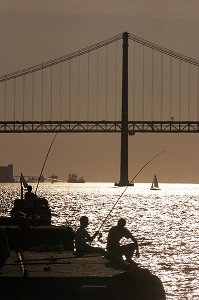 PECHEURS, COUCHE DE SOLEIL SUR LE PONT DU 25 AVRIL, CACILHAS FACE A LISBONNE SUR L'AUTRE RIVE DU TAGE, PORTUGAL 