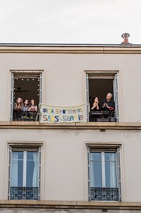 BANDEROLE 'ON VA S'EN SORTIR SANS SORTIR', ISABELLE, INFIRMIERE, OLIVIER ET LEURS TROIS FILLES SOUTIENNENT LES SOIGNANTS A 20H TOUS LES SOIRS ILS APPLAUDISSENT LES SOIGNANTS LORS DU CONFINEMENT DE LA PANDEMIE DU COVID 19, CHARENTON LE PONT, ILE DE FRANCE 