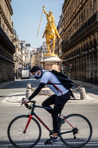 CYCLISTE MASQUE, RUE DE RIVOLI, STATUE EQUESTRE DE JEANNE D'ARC REALISEE PAR LE SCULPTEUR FRANCAIS EMMANUEL FREMIET, PARIS, 1ER ARRONDISSEMENT 