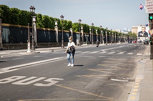 FEMME AVEC UN MASQUE TRAVERSANT LA RUE DE RIVOLI QUASI DESERTE LORS DU CONFINEMENT DE LA PANDEMIE DU COVID 19, PARIS, ILE DE FRANCE 