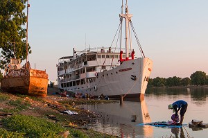 LAVEUR DE LINGES DEVANT LE BATEAU DE CROISIERE BOU EL MOGDAD DE LA COMPAGNIE DU FLEUVE, QUAI DE PODOR, SENEGAL, AFRIQUE DE L'OUEST 