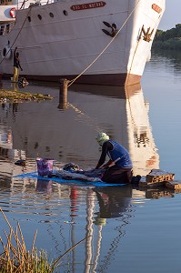 LAVEUR DE LINGES DEVANT LE BATEAU DE CROISIERE BOU EL MOGDAD DE LA COMPAGNIE DU FLEUVE, QUAI DE PODOR, SENEGAL, AFRIQUE DE L'OUEST 
