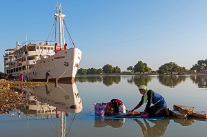 LAVEUR DE LINGES DEVANT LE BATEAU DE CROISIERE BOU EL MOGDAD DE LA COMPAGNIE DU FLEUVE, QUAI DE PODOR, SENEGAL, AFRIQUE DE L'OUEST 