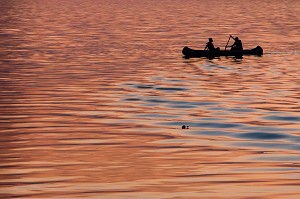 TRAVERSEE DE PIROGUES DEPUIS LA MAURITANIE SUR LE FLEUVE SUR FOND DE COUCHER DE SOLEIL, DAGANA, SENEGAL, AFRIQUE DE L'OUEST 