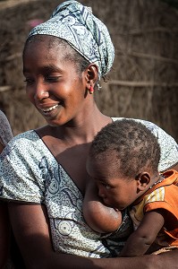 JEUNE FEMME PEULE AVEC SON BEBE, ALLAITEMENT AU SEIN, VILLAGE DES ELEVEURS NOMADES DE GOUMEL, SENEGAL, AFRIQUE DE L'OUEST 