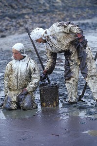 POMPIERS RAMASSANT DU MAZOUT SUR LES PLAGES. MAREE NOIRE PROVOQUEE PAR L'ERIKA. NETTOYAGE DES COTES, PLAN POLMAR, JANVIER 2000, VENDEE (85), FRANCE 