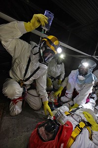 POSE D'UNE PERFUSION SUR UNE VICTIME PAR UN INFIRMIER ENCADRE LES SAPEURS-POMPIERS DU GRIMP EN TENUE DE PROTECTION CONTRE LES RADIATION, SITE DE DECONSTRUCTION DE LA TRANCHE 1 DE LA CENTRALE NUCLEAIRE EDF DU BUGEY, AIN (01), FRANCE 