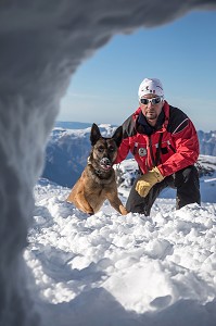 JEAN-MICHEL MORLOT ET SON BERGER BELGE MALINOIS JEEP DEVANT UN TROU DE NEIGE POUR RETROUVER UNE VICTIME, REPORTAGE SUR LES MAITRES-CHIENS D'AVALANCHE, FORMATION ORGANISEE PAR L'ANENA AVEC L'AGREMENT DE LA SECURITE CIVILE, LES-DEUX-ALPES (38), FRANCE 