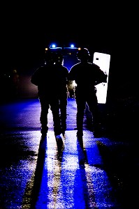 SILHOUETTE DE POLICIERS DANS LES PHARES D'UN VEHICULE, MANOEUVRE DE NUIT INTERSERVICES POMPIER/POLICE SUR LE PLATEAU TECHNIQUE, MODULE DE FORMATION VIOLENCE URBAINE, ENSOSP, ECOLE NATIONALE DES OFFICIERS DE SAPEURS-POMPIERS, AIX EN PROVENCE (13) 