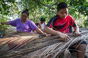 EARTH AVEC SA MERE EN TRAIN D'EFFILER LES FEUILLES COCOTIER POUR EN FAIRE DES BALAIS, FILS DE PECHEUR, ENFANT DE LA TERRE, BAN SAPHAN, THAILANDE, SERIE ENFANT DU MONDE 