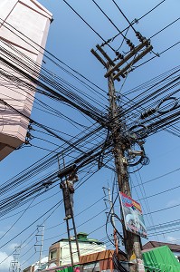 EMPLOYE AU TRAVAIL DANS L'ENCHEVETREMENT DE FILS ELECTRIQUES ET TELEPHONIQUES TYPIQUES DU RESEAU THAILANDAIS, BANG SAPHAN, THAILANDE, ASIE 