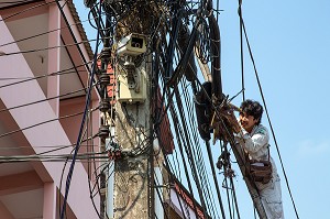 EMPLOYE AU TRAVAIL DANS L'ENCHEVETREMENT DE FILS ELECTRIQUES ET TELEPHONIQUES TYPIQUES DU RESEAU THAILANDAIS, BANG SAPHAN, THAILANDE, ASIE 