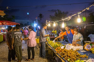 CLIENTS DEVANT UN ETALAGE DE FRUITS ET LEGUMES AU COUCHER DU SOLEIL, MARCHE DE NUIT, BANG SAPHAN, THAILANDE, ASIE 