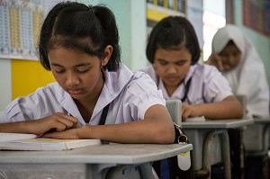 JEUNE FILLE DE PRIMAIRE EN COURS DE LECTURE, ECOLE SUAN LUNG, BANG SAPHAN, THAILANDE, ASIE 