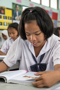 JEUNE FILLE DE PRIMAIRE EN COURS DE LECTURE, ECOLE SUAN LUNG, BANG SAPHAN, THAILANDE, ASIE 