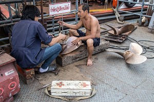 OUVRIERS AU TRAVAIL POUR LA REPARATION DES HELICES DES BATEAUX TRADITIONNELS THAILANDAIS 'LONGUE-QUEUE' PRES DE LA RIVIERE CHAO PHRAYA, BANGKOK, THAILANDE, ASIE 