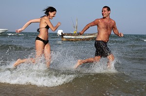 COUPLE DE VACANCIERS COURANT DANS L'EAU, PLAGE DU CORAL HOTEL, BANG SAPHAN, PROVINCE DE PRACHUAP KHIRI KHAN PROVINCE, THAILANDE, ASIE 