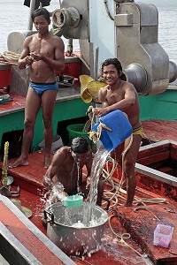 TOILETTE DES PECHEURS BIRMANS SUR LEUR BATEAU, PORT DE PECHE DE BANG SAPHAN, THAILANDE 