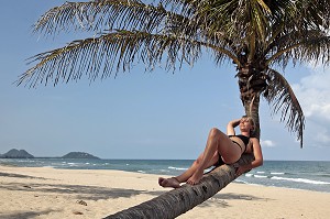 FEMME SE REPOSANT SUR UN COCOTIER, PLAGE DE BAN KRUT, BANG SAPHAN, THAILANDE, ASIE 