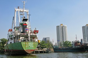 CARGO, BATEAU DE COMMERCE ET BUILDINGS, IMMEUBLES SUR LES RIVES DE LA RIVIERE CHAO PHRAYA. BANGKOK, THAILANDE 