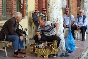 DISCUSSION ENTRE HOMMES, CHAUFFEURS DE TAXI ET LE CIREUR DE CHAUSSURES, VILLAGE DE PECHEURS DE FOCA SUR LA MER EGEE, RIVIERA DES OLIVIERS, NORD D’IZMIR, TURQUIE 