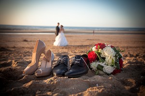 ILLUSTRATION MARIAGE, CHAUSSURES DES MARIES ET BOUQUET DE LA MARIEE SUR UNE PLAGE 