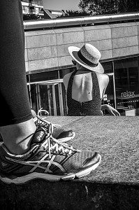 PIEDS EN BASKETS DEVANT LE DOS D'UNE FEMME AVEC UN CHAPEAU DE PAILLE, MORE LONDON RIVERSIDE, THIRD SPACE, LONDRES, GRANDE-BRETAGNE, EUROPE 