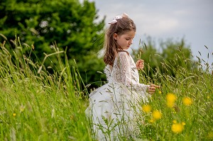 JEUNE FILLE QUI CUEILLE DES FLEURS DES CHAMPS DANS UN PRE, NORMANDIE 