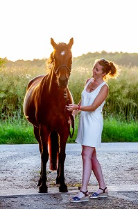 COMPLICITE ENTRE UNE JEUNE FEMME ET SON CHEVAL, NORMANDIE 