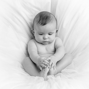 BEBE QUI JOUE AVEC SES PIEDS, NOUVEAU-NE DANS SON COUFFIN, PORTRAIT EN STUDIO 